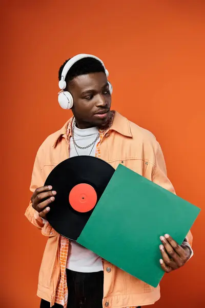Stylish, black man with headphones and record. — Stock Photo
