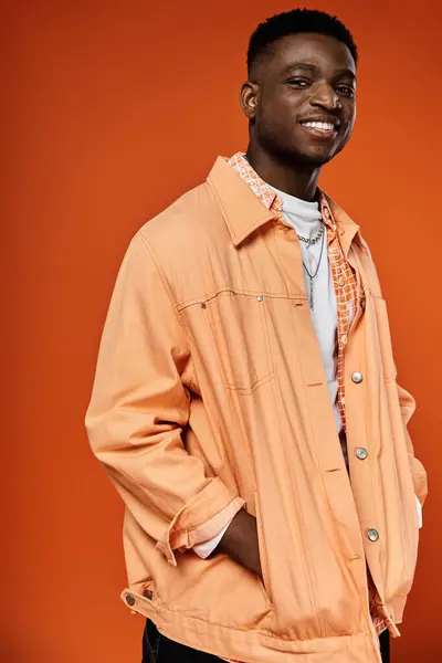 Красивый мужчина в оранжевой куртке позирует перед камерой — стоковое фото