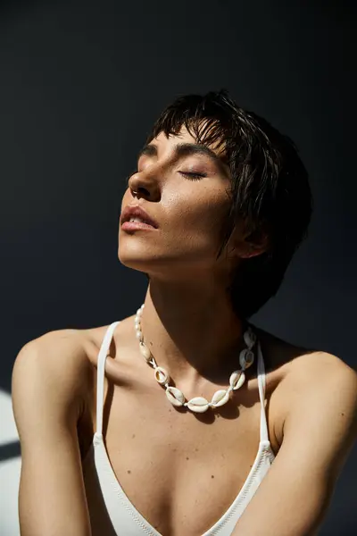 Stylish woman in white top showcases necklace. — Fotografia de Stock