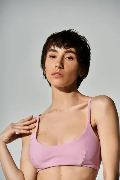Young woman confidently posing in a vibrant pink top. — Stockfoto