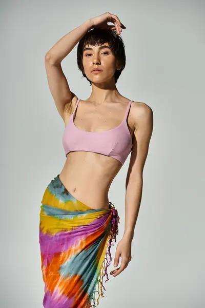 Young woman showcases vibrant style in a pink bikini and colorful sarong. — Fotografia de Stock