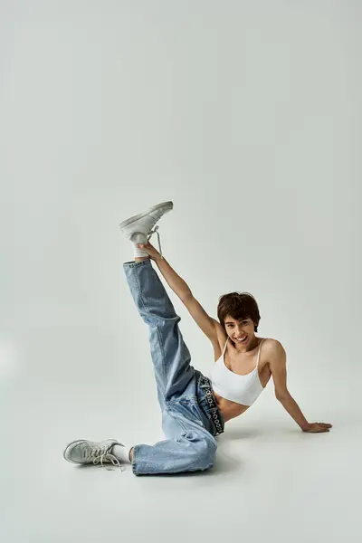 A woman energetically posing actively on a white backdrop. — Fotografia de Stock