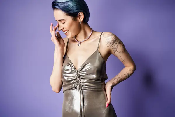 A young woman with blue hair strikes a pose in a stunning silver dress — Stock Photo