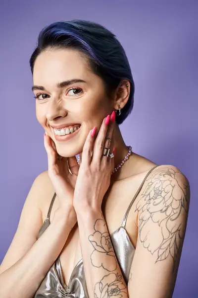 A stylish young woman with tattoos on her arms is striking a confident pose, showcasing her unique body art. — Fotografia de Stock