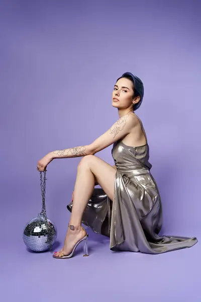 A young woman with short blue hair posing elegantly in a silver party dress — Fotografia de Stock
