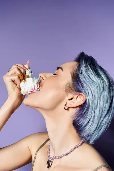 A stylish young woman with blue hair enjoying a decadent slice of cake in a glamorous setting. — Stockfoto