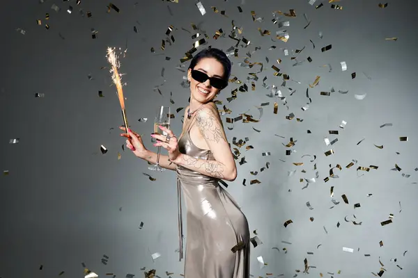Young woman in silver dress and blue hair holding champagne glass in elegant pose. — Stockfoto