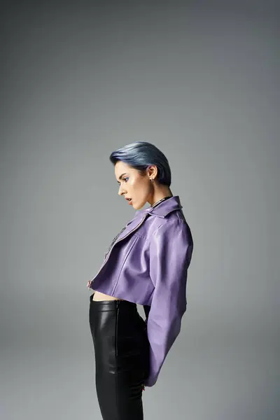 A vibrant young woman with unique short hair poses in a purple jacket and black pants in a trendy studio setting. — Stock Photo
