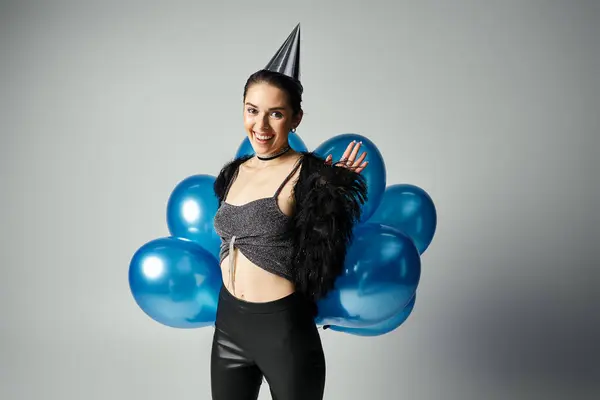 Young woman with short dyed hair striking a pose in a stylish outfit featuring a party hat and black leggings. — Fotografia de Stock