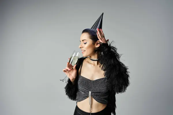 A young woman with short dyed hair dons a party hat while elegantly holding a glass of champagne — Stock Photo