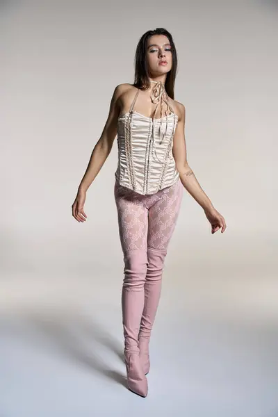 Young woman with wet hair in stylish white corset and pink pants. — Stock Photo