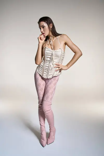 Young woman with wet hair posing elegantly in pink pants. — стокове фото