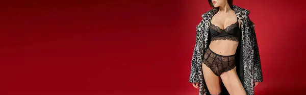 A young woman sensually poses in lingerie and a leopard print coat. — Stock Photo