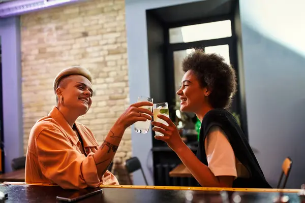 A diverse beautiful couple of lesbians enjoying a date at a cafe table. — Stock Photo