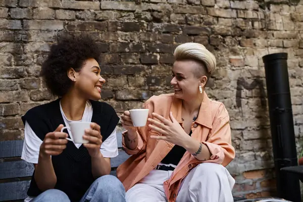 A pair of diverse lesbians enjoying a date together in a cozy cafe. — Stock Photo