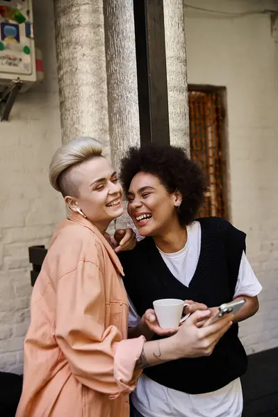 Una diversa y hermosa pareja de lesbianas de pie juntas. - foto de stock