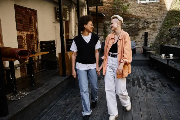 A couple of women enjoying a peaceful walk on a wooden walkway. — Stock Photo