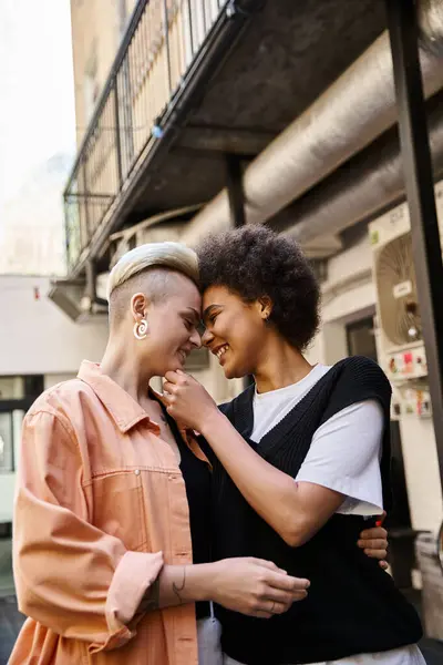 Dos mujeres hermosas y diversas se paran una al lado de la otra en un café, compartiendo un momento de conexión. - foto de stock