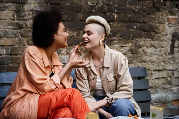 Дві різноманітні, красиві лесбіянки насолоджуються побаченням кави в стильному кафе. — стокове фото