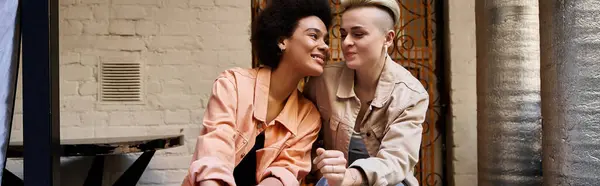Un couple diversifié et magnifique de lesbiennes profitant d'un rendez-vous ensemble sur un banc en bois dans un cadre paisible du parc. — Photo de stock