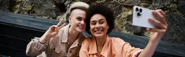 Two women at a cafe, joyfully taking a selfie with a cell phone. — Stock Photo