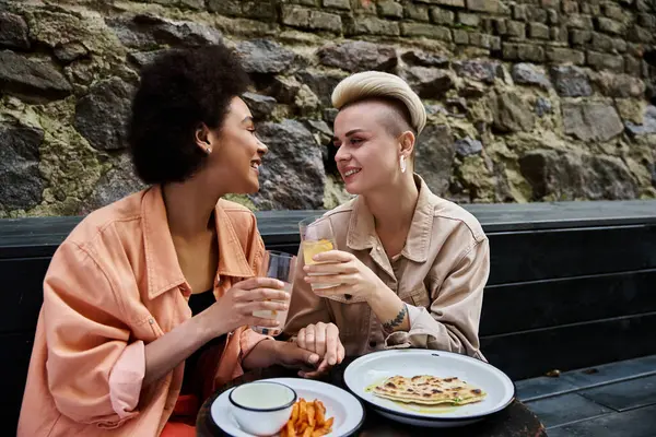 Two beautiful women enjoying a meal together at a cafe table. — Stock Photo