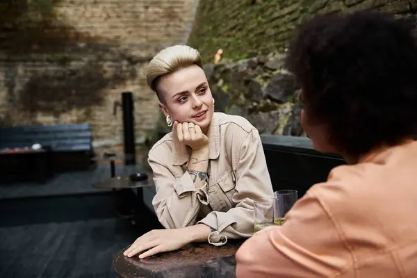 Two diverse lesbians engaged in a meaningful conversation at a cafe table. — Stock Photo