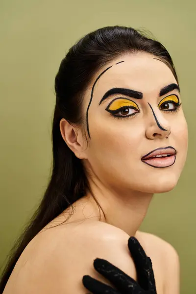 Mysterious brunette woman with yellow eyes and striking pop art makeup wearing black gloves. — Stock Photo