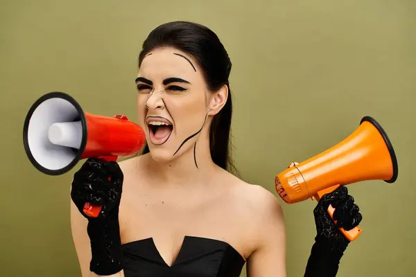 Eine stylische brünette Frau in einem schwarzen Kleid hält ein auffallend rotes und orangefarbenes Megafon in der Hand, das Zuversicht und Macht ausstrahlt. — Stockfoto