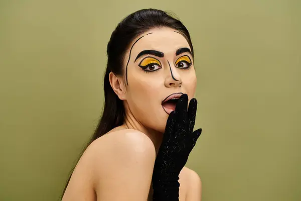 A stunning brunette woman with striking pop art makeup on her face, wearing sleek black gloves. — Stock Photo