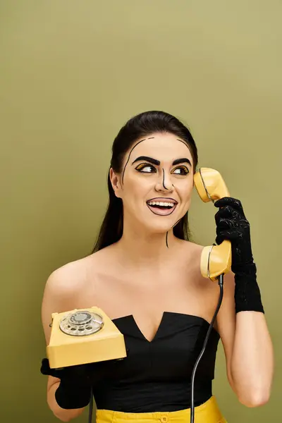 Brunette woman in pop art makeup and black gloves, captivated as she holds a phone up to her face. — Stock Photo