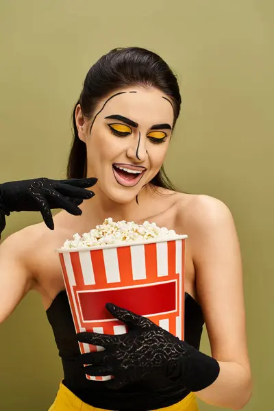 Eine stilvolle brünette Frau in schwarzen Handschuhen hält eine Schachtel Popcorn in der Hand. — Stockfoto