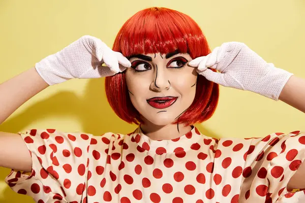 A woman with red hair and white gloves covering her eyes, clad in pop art makeup and polka dot blouse on a yellow background. — Stock Photo