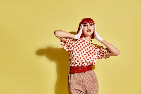 A pretty redhead woman with creative pop art makeup in a polka dot shirt on a yellow background. — Stock Photo