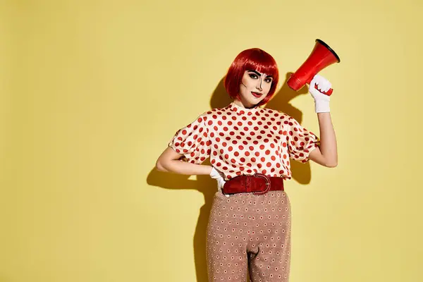 Hübsche rothaarige Frau mit Pop-Art-Make-up frisiert ihre roten Haare mit einem rot-weißen Retro-Föhn auf gelbem Hintergrund. — Stockfoto
