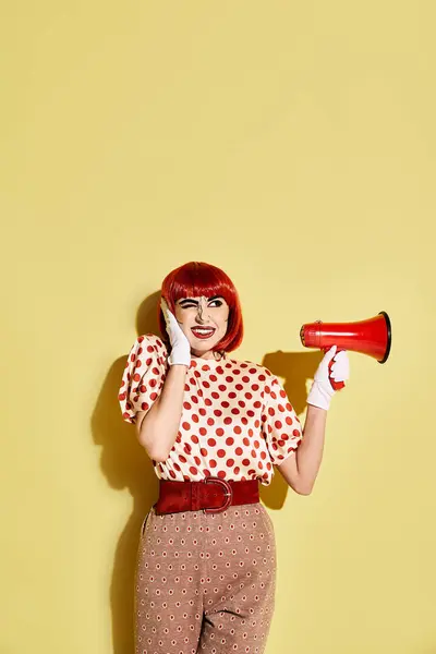 Rotschopf im Polka-Dot-Shirt mit rot-weißem Megafon auf gelbem Hintergrund. — Stockfoto