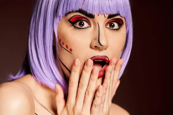 Une femme aux cheveux violets et au maquillage pop art halète, les mains couvrant sa bouche de crainte. — Photo de stock