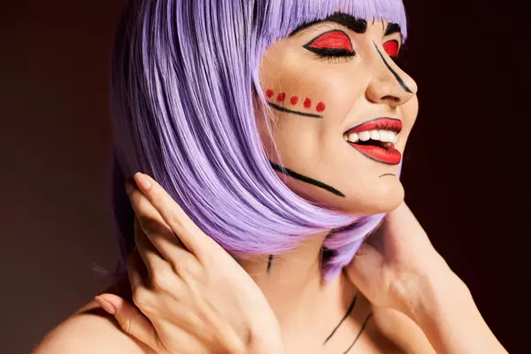 Una donna sorprendente con i capelli viola e pittura viso artistico ispirato da fumetti su uno sfondo nero. — Foto stock