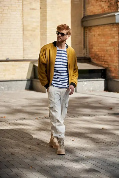 A stylish redhead man strolling the city streets in a vibrant yellow jacket. — Stock Photo