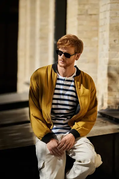 Red-haired man chilling on bench, looking cool in sunglasses. — Stock Photo