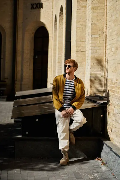 Young red haired man posing in front of city building. — Stock Photo