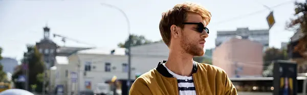 A debonair young man with red hair walks down the street in a bright yellow cardigan. — Stock Photo