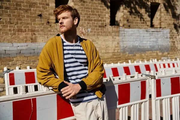 Young red-haired man in debonair attire standing confidently in front of a brick wall. — Stock Photo