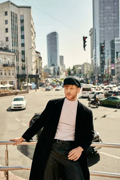 A young red-haired man in dapper attire leaning thoughtfully on a city rail. — Stock Photo