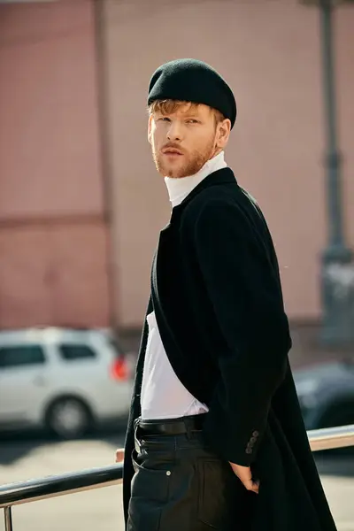 Red-haired man in black coat and white shirt walking in city. — Stock Photo