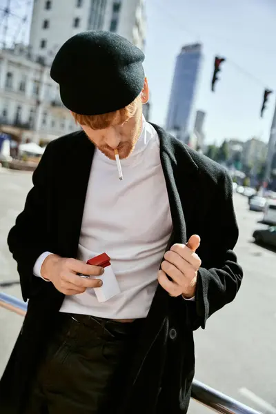 Un hombre elegante con un sombrero negro fumando cigarrillo. - foto de stock
