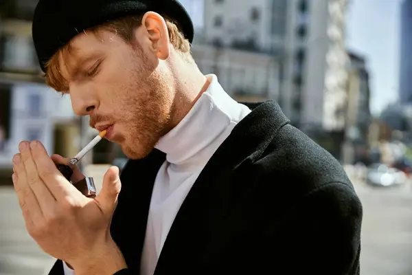 A young, stylishly dressed man with red hair smoking a cigarette on a city street. — Stock Photo