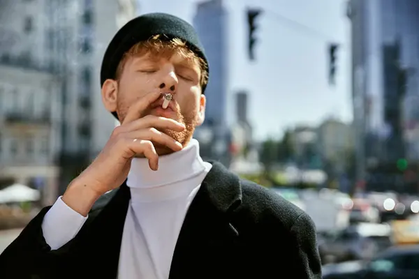 Stylish redhead man smoking cigarette on city sidewalk. — Stock Photo