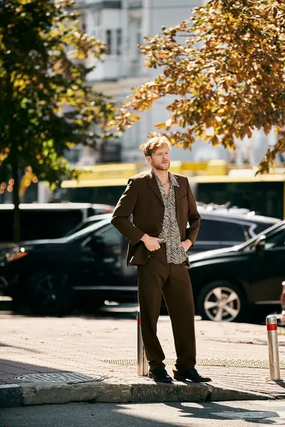 A debonair young man with red hair in a suit standing on a city sidewalk. — Stock Photo