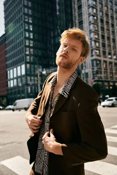 A young red haired man in debonair attire standing confidently in the middle of a crosswalk in the city. — Stock Photo